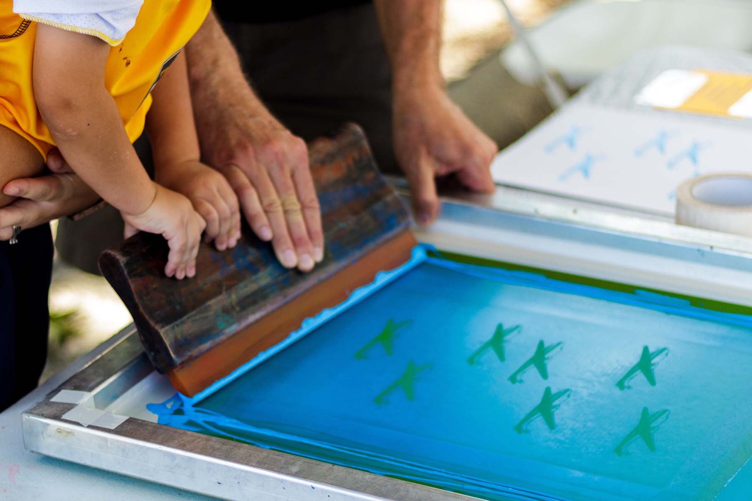 Lavorazione serigrafica: mani al lavoro su un telaio